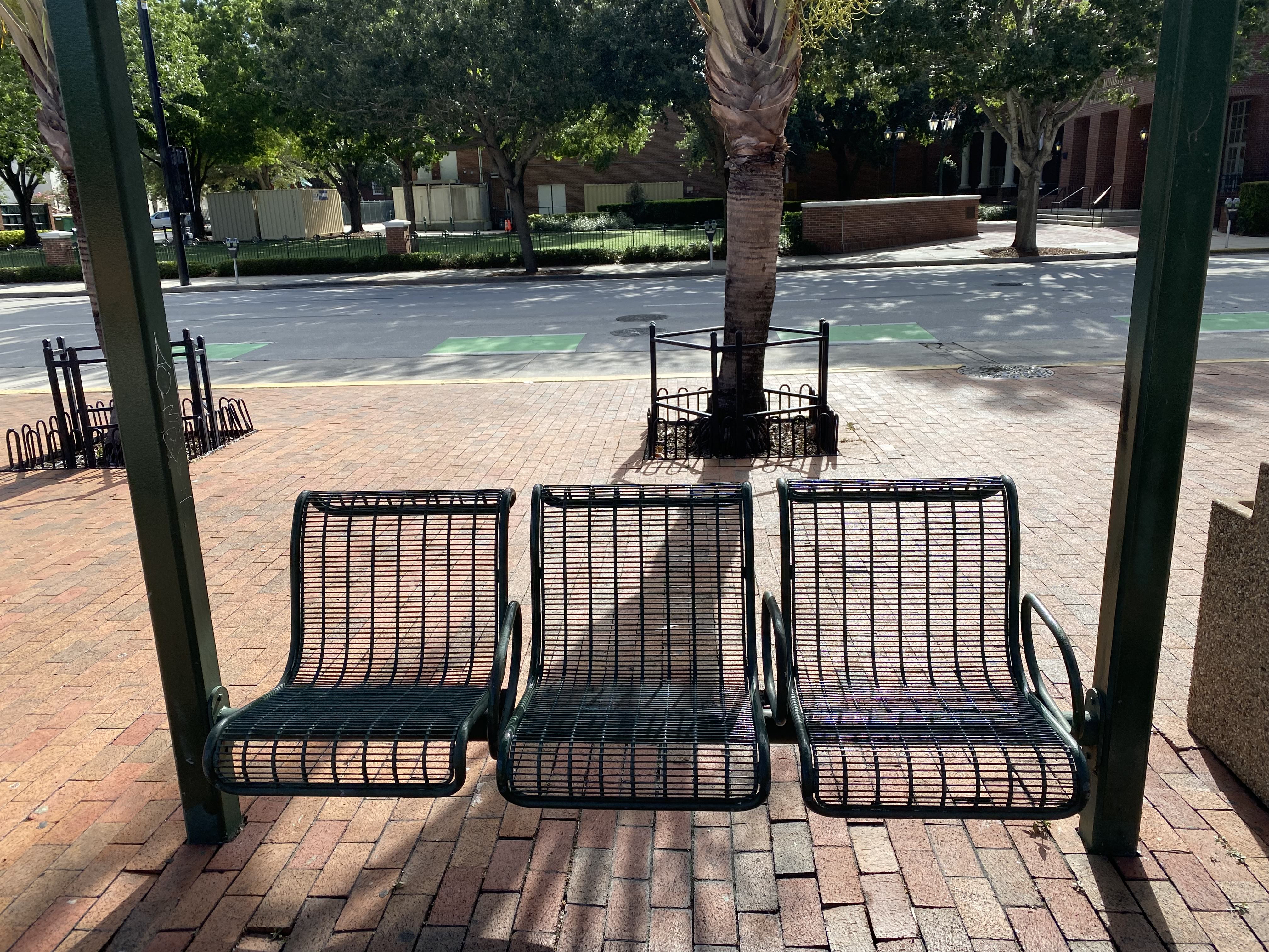 A bench divided into three parts with two metal separators.